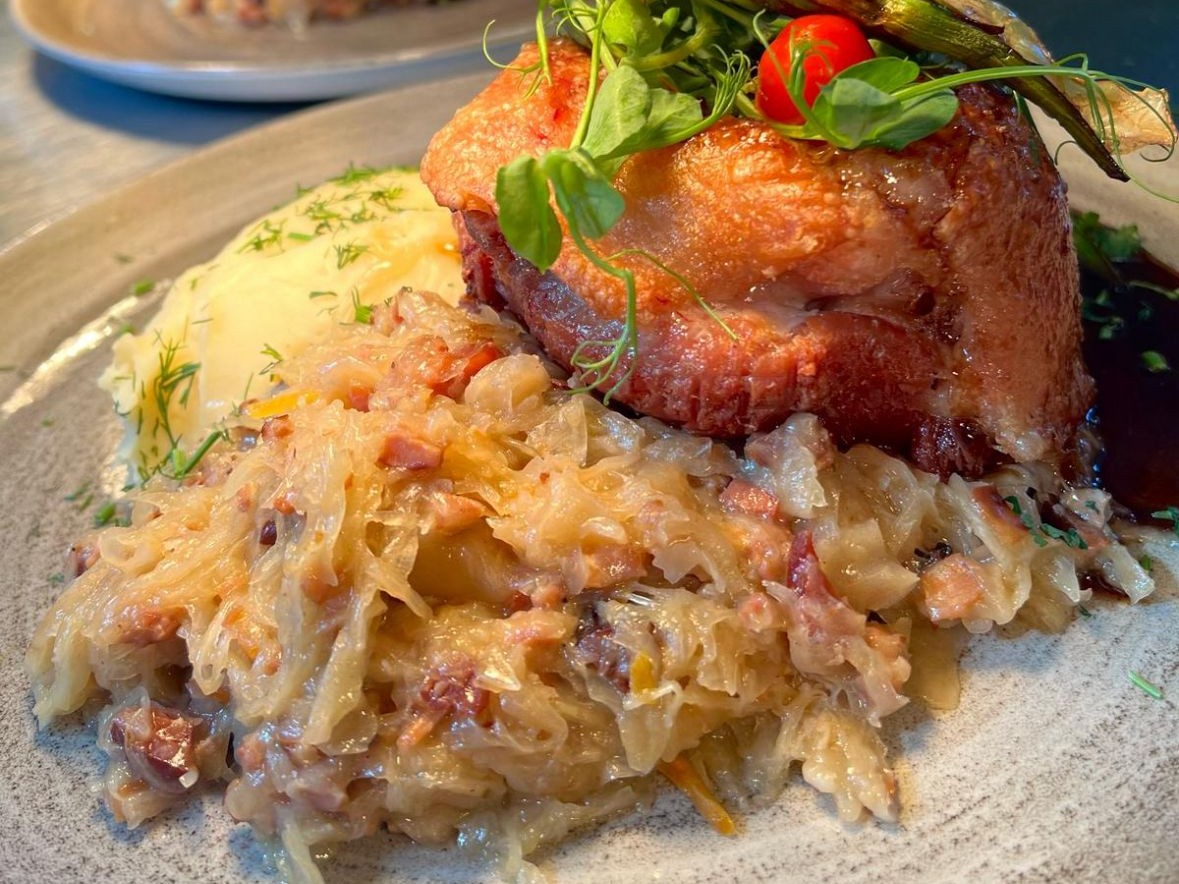 Photo of ham hock served with sauerkraut and mashed potatoes